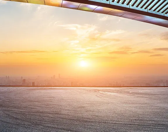 Sunset over city with road in foreground