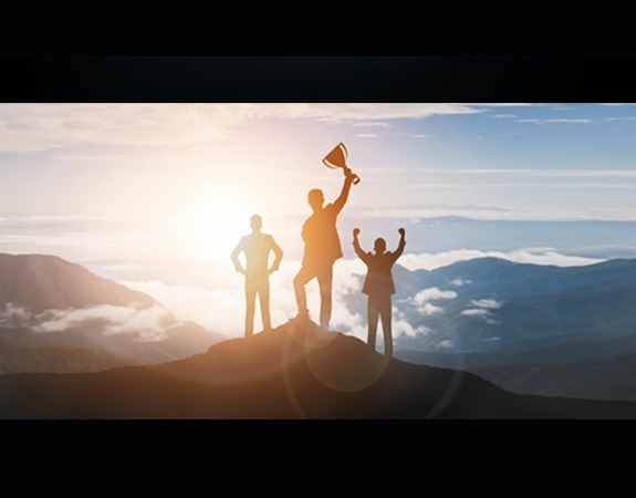 People on mountain holding a trophy