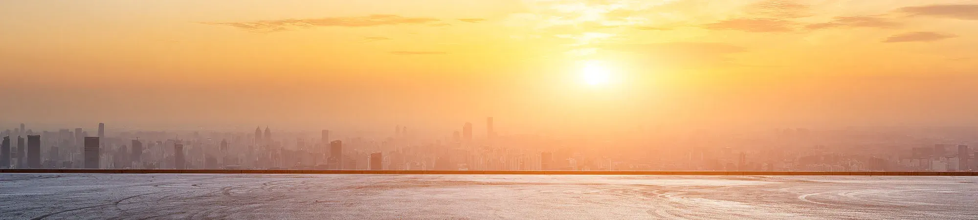 Sunset over city with road in foreground