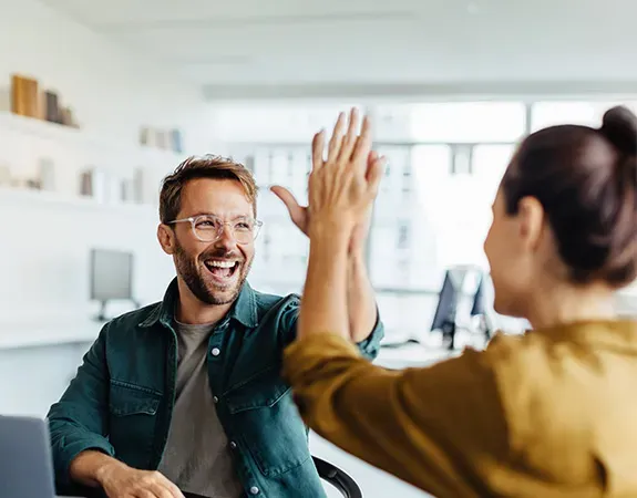 Man and woman clapping hands in office