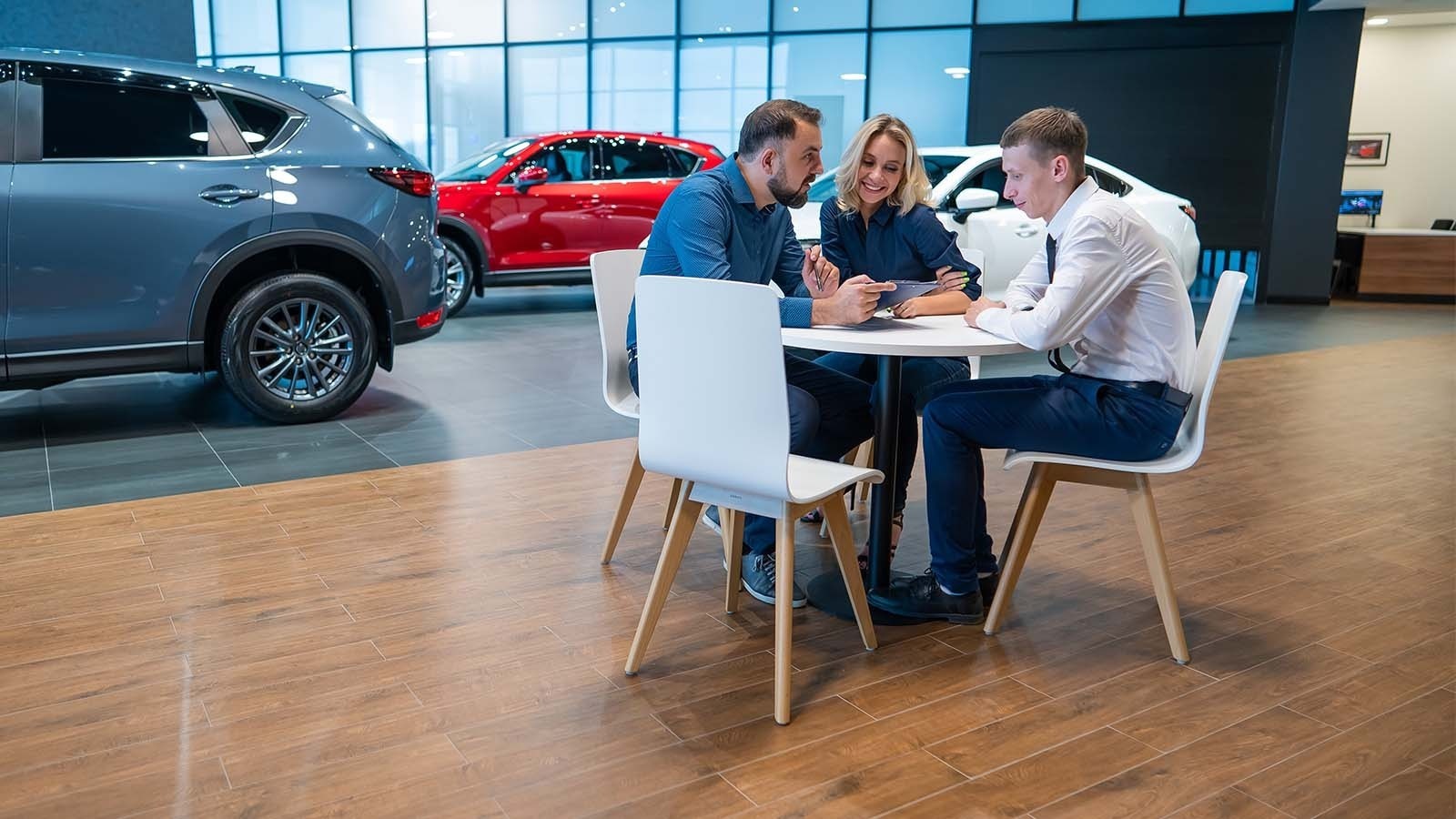 Customers speaking to a sales representative at a car dealership